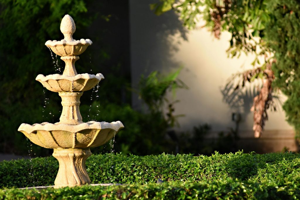 A stunning stone garden fountain surrounded by lush greenery in Coral Gables, Florida.